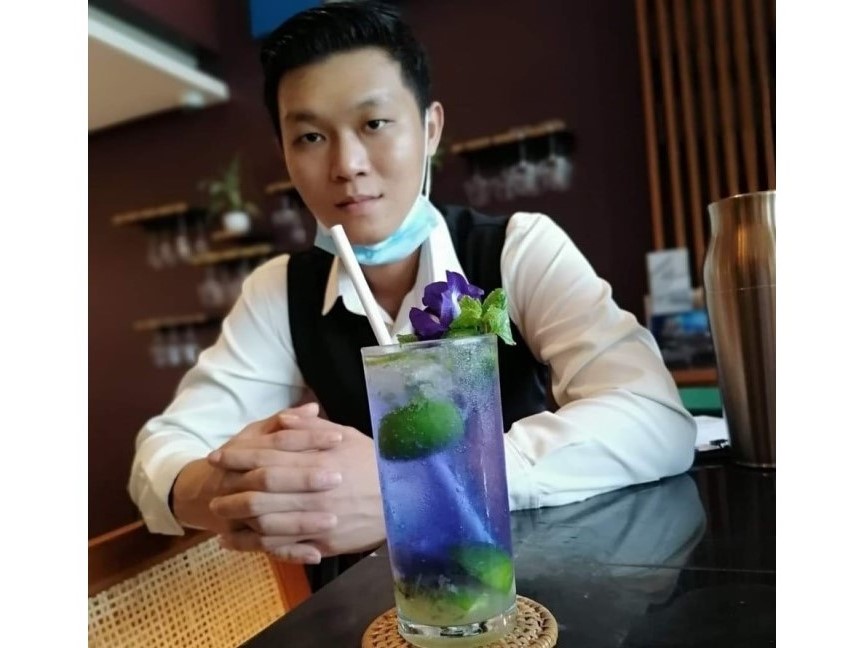 Alexander, bartender mit einem blauen Mojito in Yangon. Auch Sie können kreativ sein und Ihr eigenes Getränk kreieren!